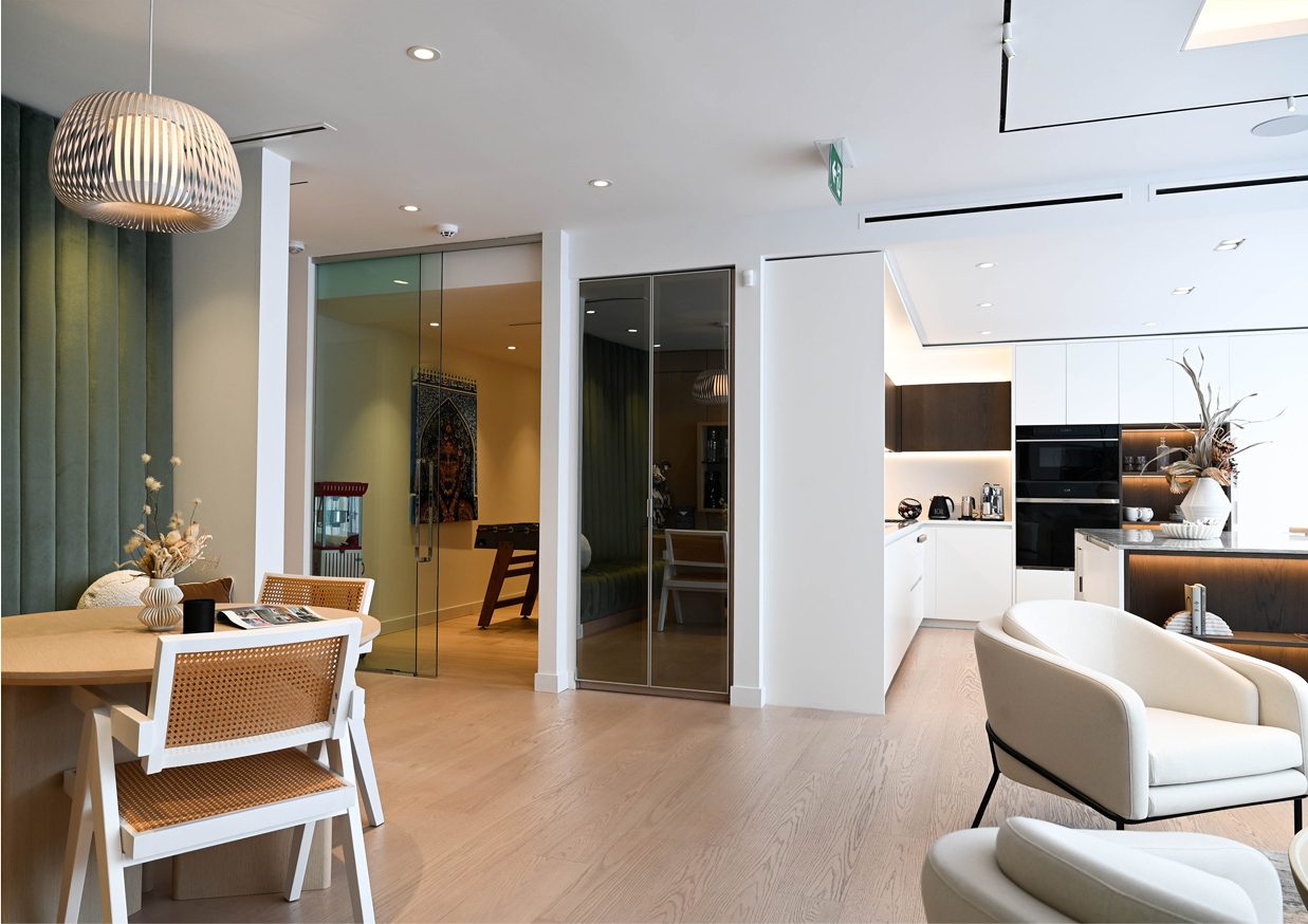 Espace salon ouvert donnant sur la cuisine, avec fauteuils et table à manger